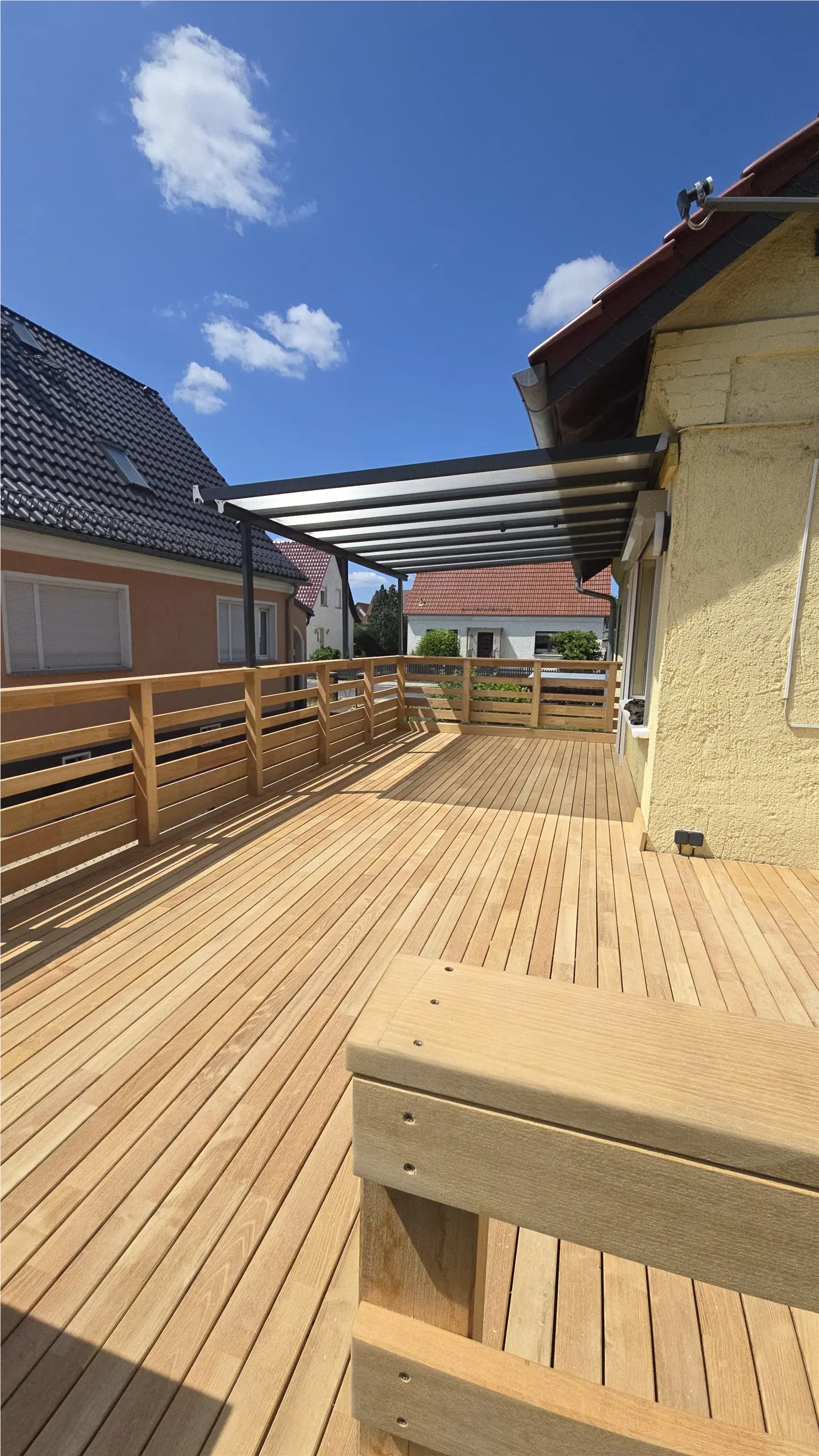 Fertige Holzterrasse mit Geländer und sauber ausgeführten Anschlüssen