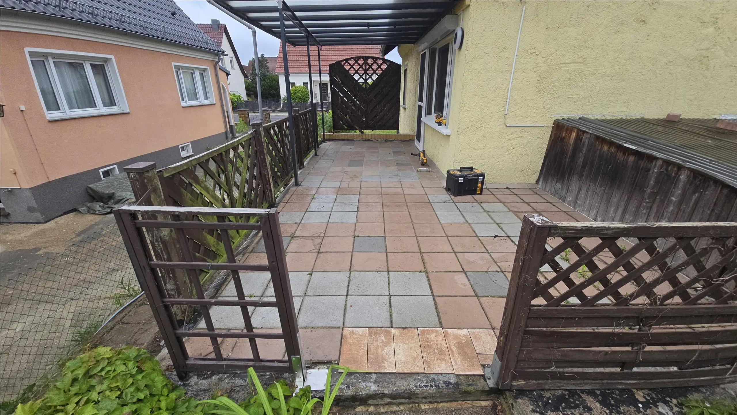 Terrassenfläche mit alten roten und grauen Platten vor dem Umbau