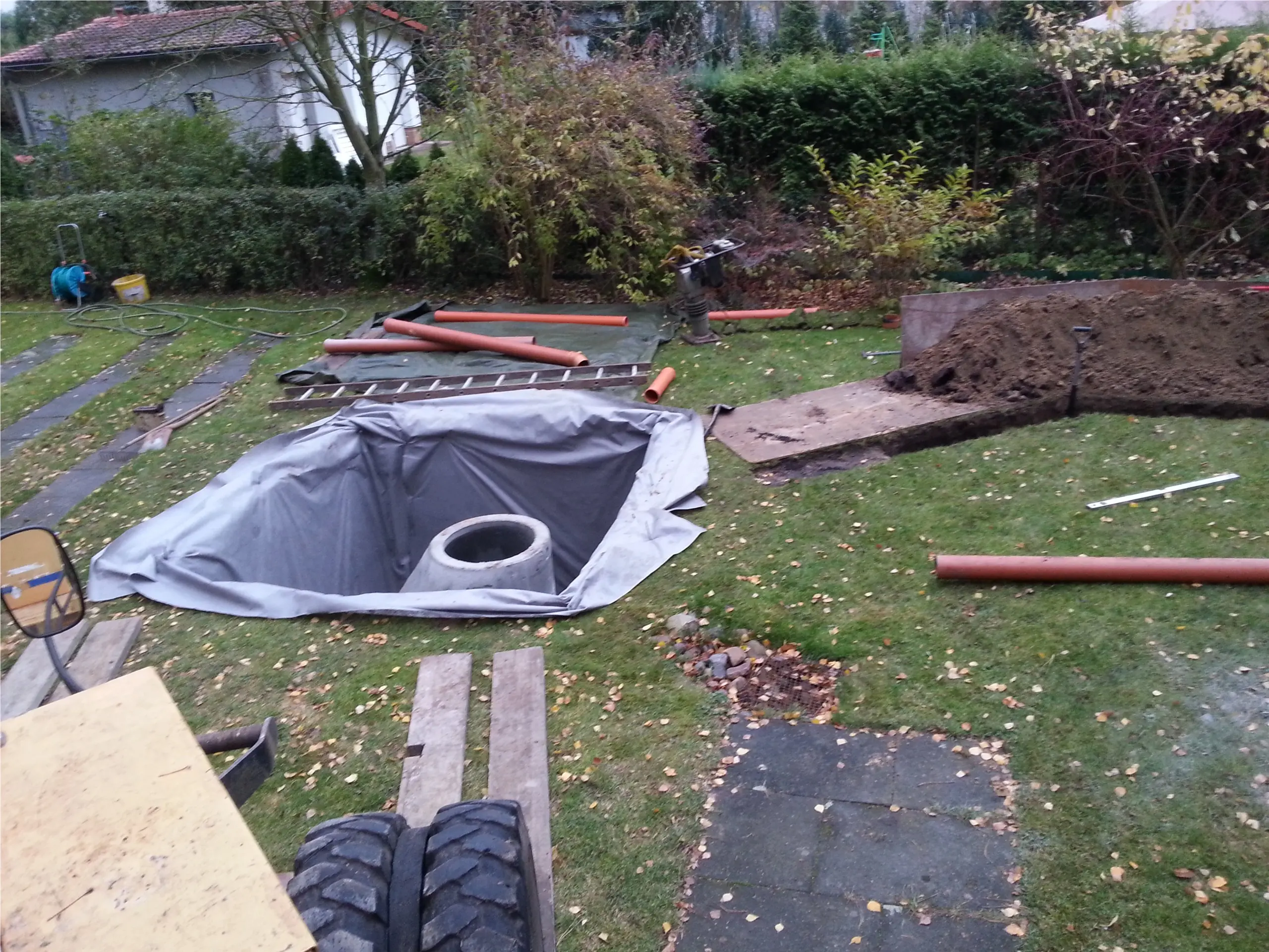 Offene Baugrube mit Filtervlies, Schachtkörper und eingebrachtem Drainagematerial